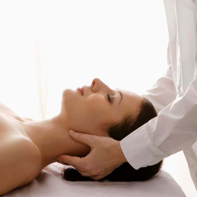 Relaxed woman on massage table receiving a Jikiden Reiki session.
