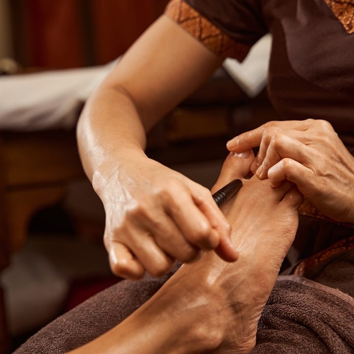 The foot of a woman receiving a reflexology treatment.